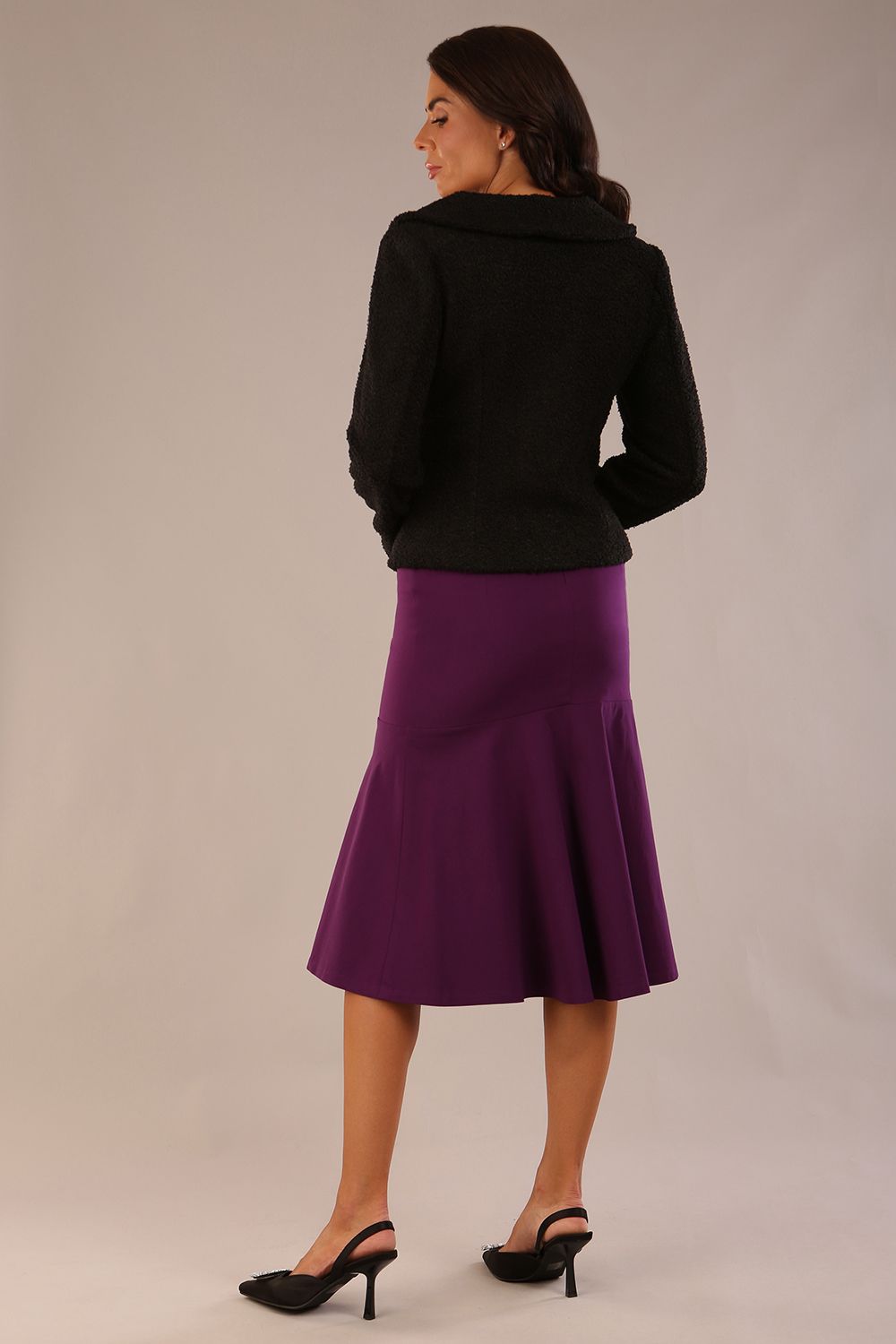 Model wearing the Truro floral top, showing the standard hip-length and draped V-neck and purple marlene skirt against a gray background (Purple)