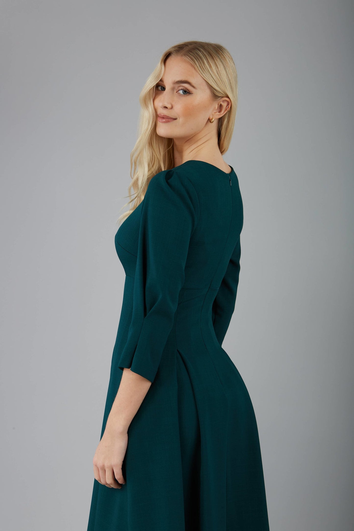 blonde model is wearing diva catwalk harpsden a-line skirt 3/4 sleeve swing dress with rounded neckline in forest green front