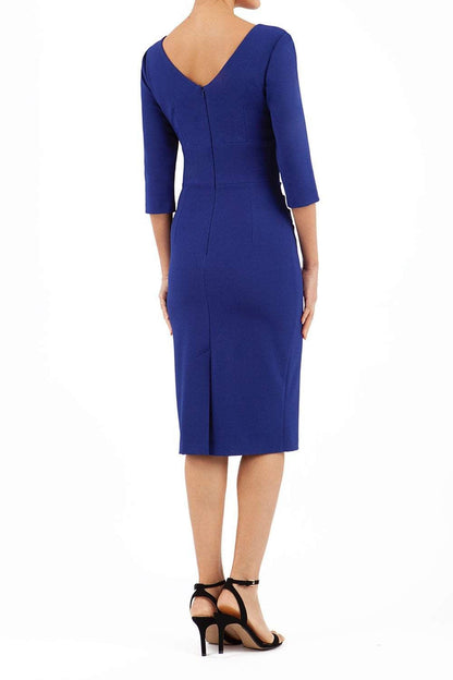 A model is wearing a three quarter sleeve pencil dress with a round neckline and bow detail at the front in oxford blue