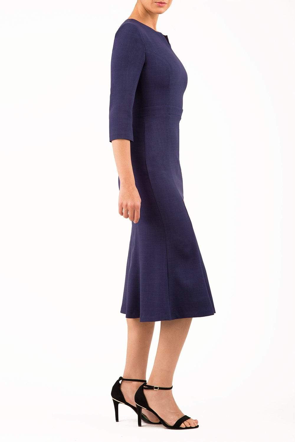 blonde model is wearing diva catwalk senne midaxi sleeved dress with fishtail and rounded neckline with a slit in the middle in navy front