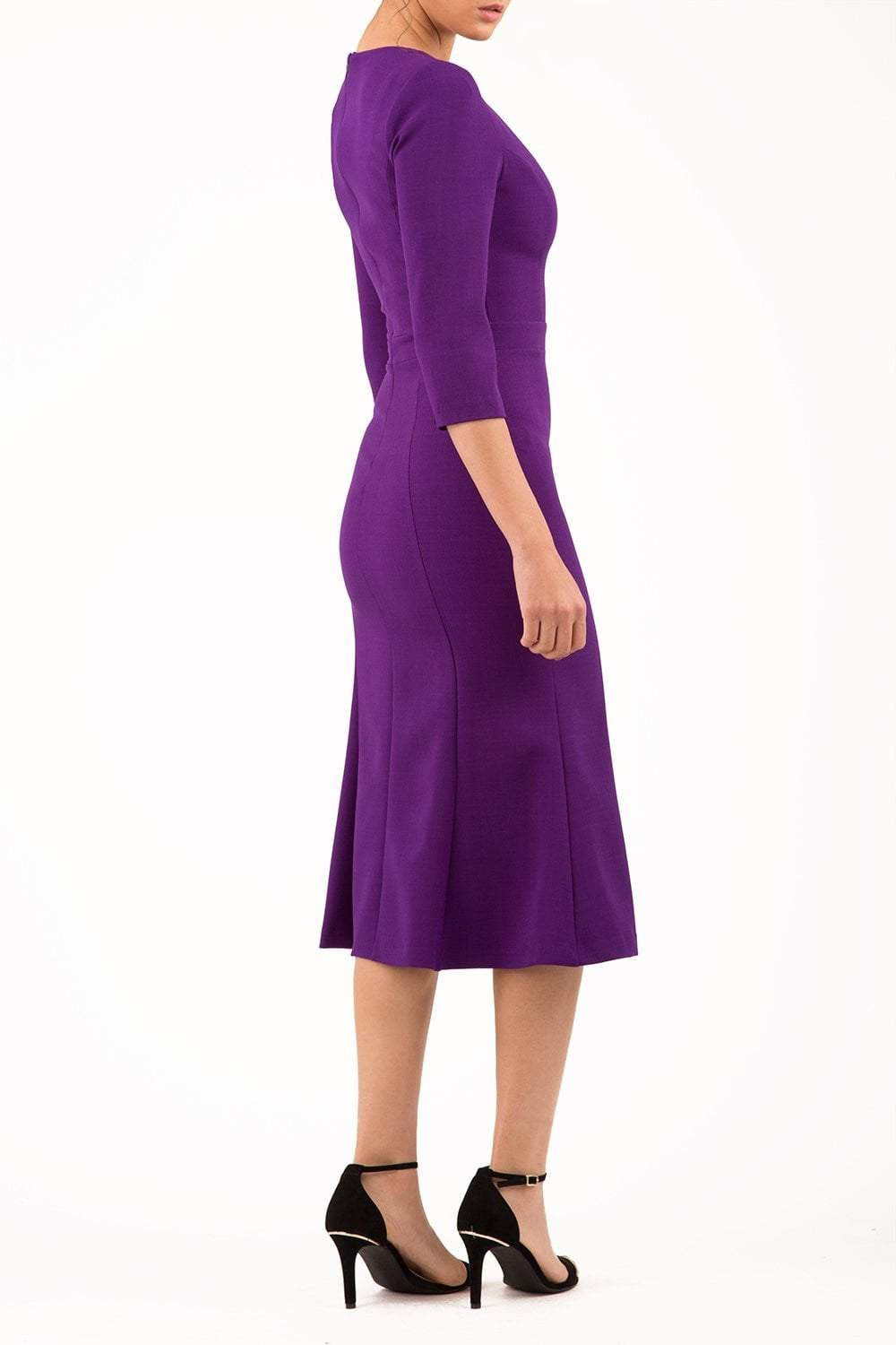 blonde model is wearing diva catwalk senne midaxi sleeved dress with fishtail and rounded neckline with a slit in the middle in purple front