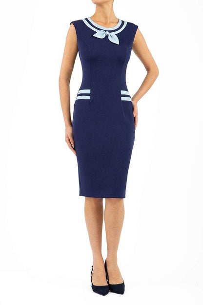 model wearing diva catwalk navy blue tempo pencil dress with pocket detail and rounded neckline with bow detail front blue